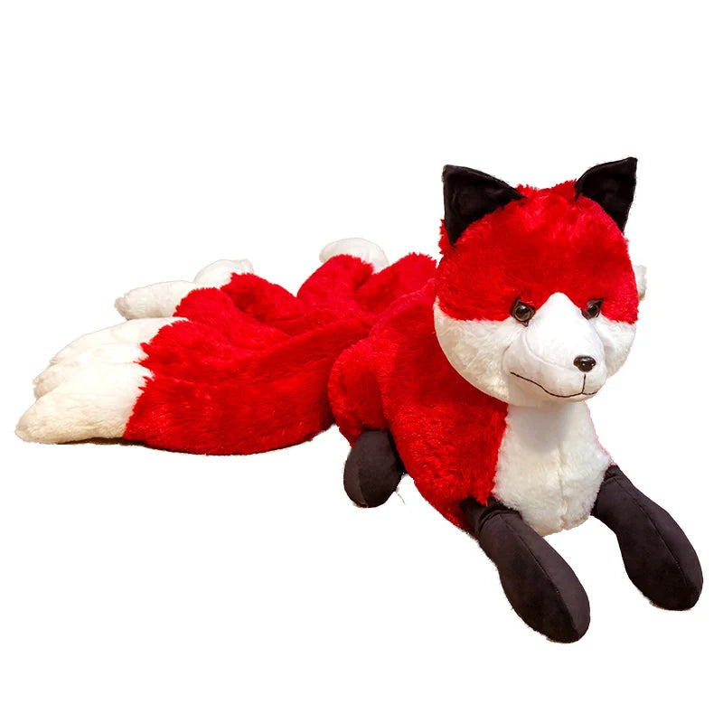 Peluche renard fantastique à neuf queues rouge et blanche couchée sur un canapé dans une chambre.